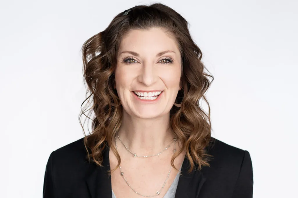 A woman smiles at the camera against a white background.